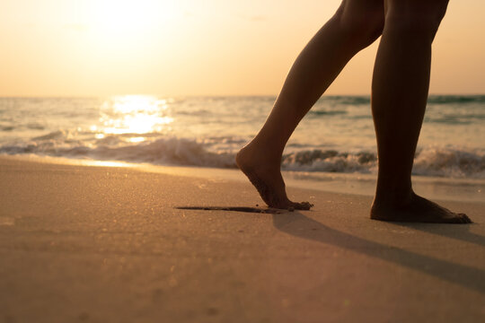A soft-focus image of a person walking barefoot on grass near water, symbolising vulnerability, grounding, and the human journey of choice and self-discovery.